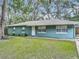 Inviting single-story home featuring a well-maintained lawn and a charming facade with mature landscaping at 1331 Needle Palm Dr, Edgewater, FL 32132
