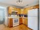 A kitchen with oak cabinets, mosaic backsplash, and white appliances is both functional and stylish at 1331 Needle Palm Dr, Edgewater, FL 32132