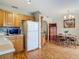 Eat-in kitchen featuring a dining table, wood cabinets, and white appliances is both functional and stylish at 1331 Needle Palm Dr, Edgewater, FL 32132
