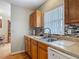 A kitchen sink with wood cabinets, mosaic backsplash, and a window at 1331 Needle Palm Dr, Edgewater, FL 32132