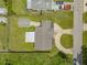 An aerial view of a well-manicured lawn with a detached garage and screened in patio at 2416 Pine Tree Dr, Edgewater, FL 32141