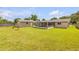 Well-manicured backyard with an enclosed lanai, storage shed, and privacy fencing offers a great retreat at 2416 Pine Tree Dr, Edgewater, FL 32141