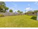 Large fenced backyard with lush grass and mature landscaping offer ample space for recreation at 2416 Pine Tree Dr, Edgewater, FL 32141