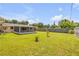 Large backyard with lush grass, partial fencing, and an enclosed lanai provides ample privacy at 2416 Pine Tree Dr, Edgewater, FL 32141