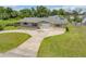 An eye-level view of the charming home featuring a well-maintained front yard and driveway at 2416 Pine Tree Dr, Edgewater, FL 32141