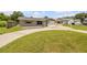 Inviting home featuring a manicured lawn and tidy driveway, showcasing curb appeal at 2416 Pine Tree Dr, Edgewater, FL 32141