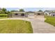 Charming home with a well-kept lawn and neat driveway, creating a welcoming atmosphere at 2416 Pine Tree Dr, Edgewater, FL 32141