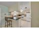 Bright eat-in kitchen features tile floors, white cabinets, granite countertops, and breakfast bar seating at 2416 Pine Tree Dr, Edgewater, FL 32141