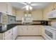 Bright kitchen with white cabinets, stainless steel appliances, and tile floors at 2416 Pine Tree Dr, Edgewater, FL 32141