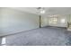 A spacious living room featuring carpet and a ceiling fan for added comfort at 2416 Pine Tree Dr, Edgewater, FL 32141