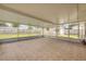 Screened patio with tile flooring looking out into yard and detached garage at 2416 Pine Tree Dr, Edgewater, FL 32141