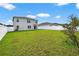 Large backyard features a white fence and ample green space, perfect for outdoor activities at 2667 Neverland Dr, New Smyrna Beach, FL 32168
