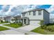 Two-story home featuring an attached two-car garage, well-maintained lawn, and front porch at 2667 Neverland Dr, New Smyrna Beach, FL 32168