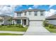 Exterior of home with two-car garage, covered porch, and professionally landscaped yard at 2667 Neverland Dr, New Smyrna Beach, FL 32168