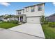 Two-story home with manicured lawn, two-car garage, and covered porch with decorative columns at 2667 Neverland Dr, New Smyrna Beach, FL 32168