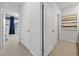 Hallway with doors to bedrooms and bathrooms, featuring neutral tile and carpet at 2667 Neverland Dr, New Smyrna Beach, FL 32168