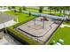 Aerial view of a fenced playground with swings, slides, and a seating area at 2667 Neverland Dr, New Smyrna Beach, FL 32168