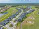Expansive aerial view showcases a community nestled alongside a golf course and lakes, creating a picturesque residential setting at 2939 Bella Flore Ter, New Smyrna Beach, FL 32168