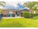 Lush backyard featuring green lawn, patio area with chairs, and manicured landscaping at 2939 Bella Flore Ter, New Smyrna Beach, FL 32168
