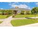 Inviting single-story home featuring a beautifully landscaped front yard with palm trees and a paver walkway at 2939 Bella Flore Ter, New Smyrna Beach, FL 32168