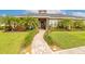 Inviting single-story home featuring a beautifully landscaped front yard with palm trees and a paver walkway at 2939 Bella Flore Ter, New Smyrna Beach, FL 32168