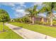 Side view of a three car garage with a beautifully landscaped yard and sidewalk in front at 2939 Bella Flore Ter, New Smyrna Beach, FL 32168