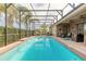 Large backyard pool and patio with outdoor seating and screened enclosure at 2939 Bella Flore Ter, New Smyrna Beach, FL 32168