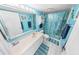 Bright blue bathroom featuring a single sink vanity and a shower with a seashell-themed curtain at 2967 S Atlantic Ave # 508, Daytona Beach, FL 32118