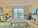 Bright, comfortable living room with plush leather seating and a large sliding door showcasing a beautiful ocean view at 30 Inlet Harbor Rd # 606, Ponce Inlet, FL 32127