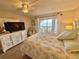 Inviting bedroom with a queen bed, dresser, ceiling fan and ocean view balcony at 30 Inlet Harbor Rd # 606, Ponce Inlet, FL 32127