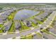 Aerial view of neighborhood homes surrounding a pond with a fountain at 3116 Crab Trap Dr, New Smyrna Beach, FL 32168