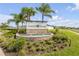 Welcoming Coastal Woods entrance with stone fountain, lush landscaping, and mature palm trees at 3116 Crab Trap Dr, New Smyrna Beach, FL 32168