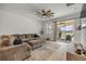 Living room with a large sectional sofa, ceiling fan, and sliding glass doors to the screened lanai at 3116 Crab Trap Dr, New Smyrna Beach, FL 32168