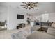 Open-concept living room with a large TV, comfortable seating, and a view of the kitchen and bedroom at 3116 Crab Trap Dr, New Smyrna Beach, FL 32168
