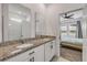 Main bathroom featuring granite countertops, dual sinks, and a walk-in shower, leading to the bedroom at 3116 Crab Trap Dr, New Smyrna Beach, FL 32168