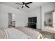Main bedroom with a ceiling fan, TV, walk-in closet, and ensuite bathroom at 3116 Crab Trap Dr, New Smyrna Beach, FL 32168