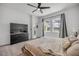 Main bedroom with a large TV, ceiling fan, and ensuite bathroom, offering a comfortable retreat at 3116 Crab Trap Dr, New Smyrna Beach, FL 32168