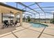 Spacious screened-in patio with pool, grill, outdoor seating and lake view at 3116 Crab Trap Dr, New Smyrna Beach, FL 32168
