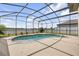 Screened-in pool with a spa and view of the backyard at 3116 Crab Trap Dr, New Smyrna Beach, FL 32168