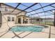 Screened-in pool and covered patio with view of backyard and white fence at 3116 Crab Trap Dr, New Smyrna Beach, FL 32168
