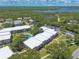 Aerial view displays complex nestled amongst trees, near waterways with parking at 3800 Saxon Dr # 180, New Smyrna Beach, FL 32169