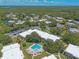 An aerial view shows the community layout, mature trees, and the pristine pool area at 3800 Saxon Dr # 180, New Smyrna Beach, FL 32169