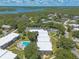 Aerial view showcasing the community and pool with lush landscaping and nearby waterways at 3800 Saxon Dr # 180, New Smyrna Beach, FL 32169