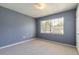 A cozy bedroom with neutral carpeting, ample light, and a view to the outside at 3800 Saxon Dr # 180, New Smyrna Beach, FL 32169