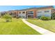 Inviting two-story condo with brick accents, lush lawn, and a welcoming walkway at 3800 Saxon Dr # 180, New Smyrna Beach, FL 32169