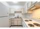 Efficient kitchen featuring white appliances and cabinets, maximizing space at 3800 Saxon Dr # 180, New Smyrna Beach, FL 32169