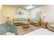Living area with rattan sofas, glass coffee table, and coastal decor at 3800 Saxon Dr # 180, New Smyrna Beach, FL 32169