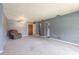 Open-concept living room with plush carpet, ceiling fan, and access to kitchen at 3800 Saxon Dr # 180, New Smyrna Beach, FL 32169