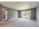 A bright living room featuring sliding glass doors and neutral carpeting at 3800 Saxon Dr # 180, New Smyrna Beach, FL 32169