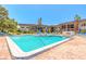 A large, sparkling pool is surrounded by lounge chairs and a brick patio at 3800 Saxon Dr # 180, New Smyrna Beach, FL 32169